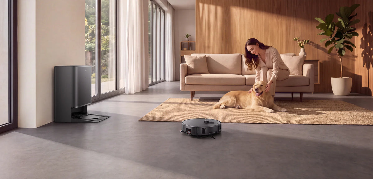 Vrouw met hond op het kleed terwijl de Xiaomi Robot Vacuum 6 Max de woonkamer zuigt