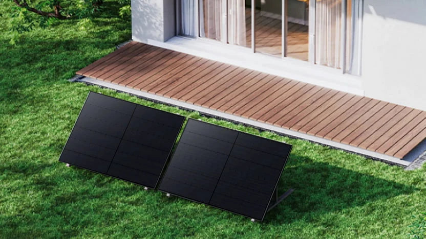 Twee zonnepanelen opgesteld op een grondmontagesysteem in de tuin, geschikt voor gebruik met de Anker SOLIX Solarbank Max AC thuisbatterij.