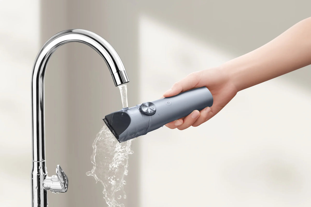 Hand spoelt de Xiaomi Hair Clipper 2 af onder een kraan