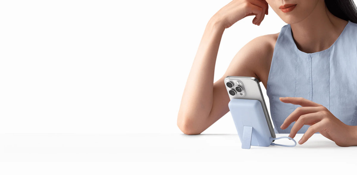 Vrouw kijkt naar haar telefoon op de standaard van de Xiaomi Magnetic Power Bank 10000