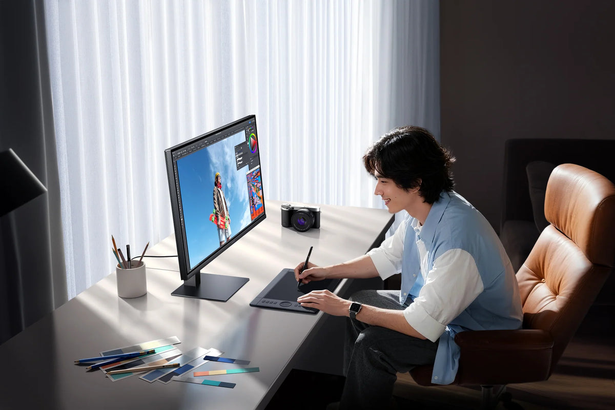Fotobewerker aan een bureau met de Xiaomi 2K Monitor A27Qi 2026 bij daglicht