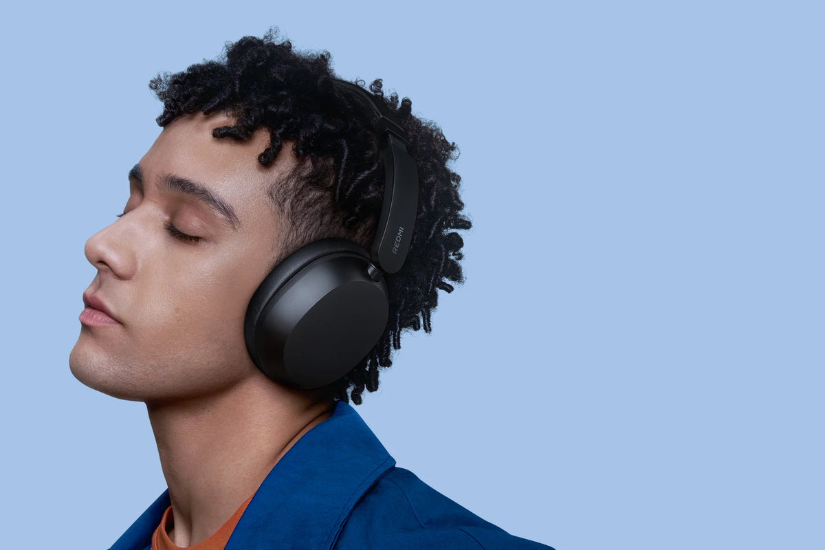 Man luistert met gesloten ogen naar muziek op de zwarte Xiaomi Redmi Headphones Neo