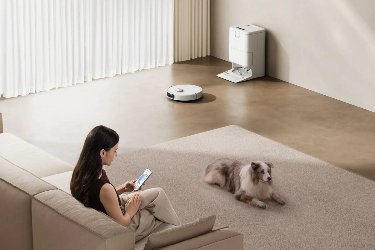 Xiaomi Robot Vacuum H50 Pro rijdt door de woonkamer terwijl iemand op de bank zit