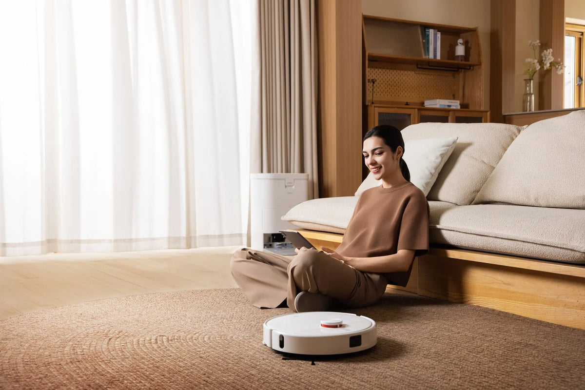 Xiaomi Robot Vacuum H50 rijdt door de woonkamer terwijl iemand op de bank zit