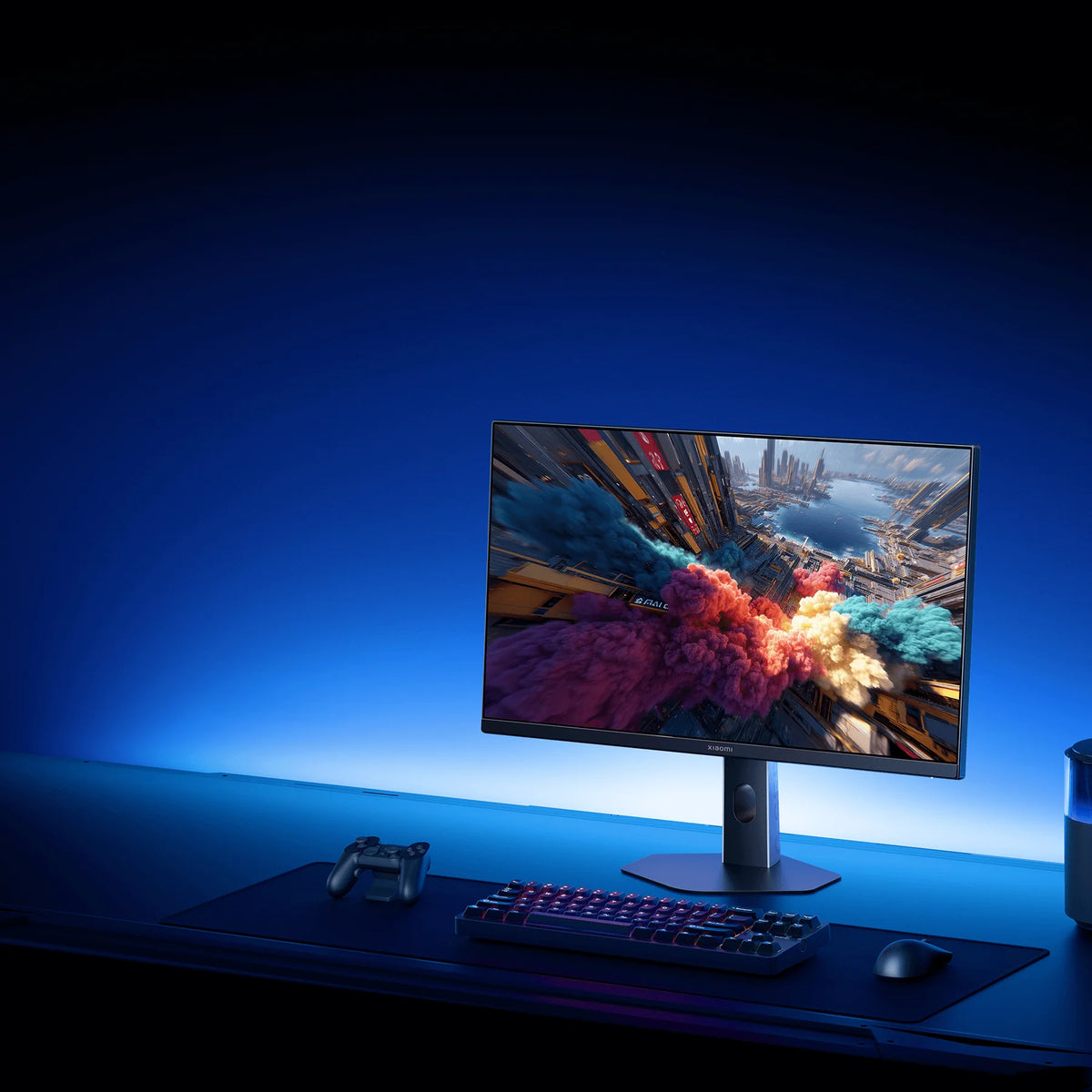 Xiaomi Gaming Monitor G24i 2026 op een donker gamebureau met blauw licht, toetsenbord en speaker