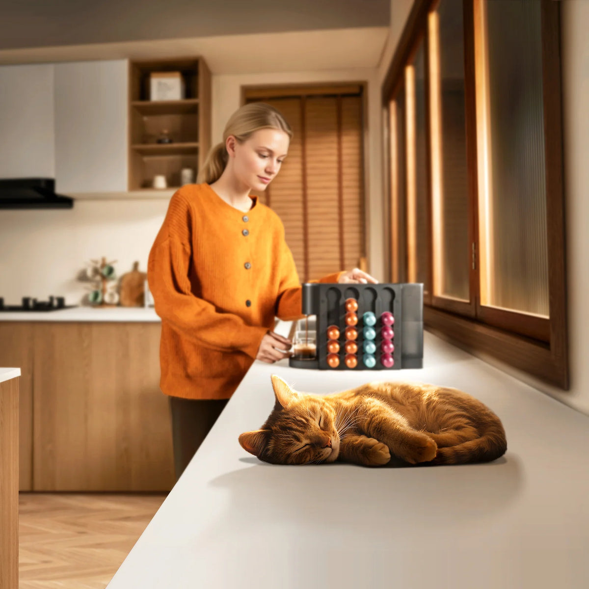 Vrouw pakt een capsule bij de Xiaomi Mijia Capsule Coffee Machine op het aanrecht, met een kat ernaast