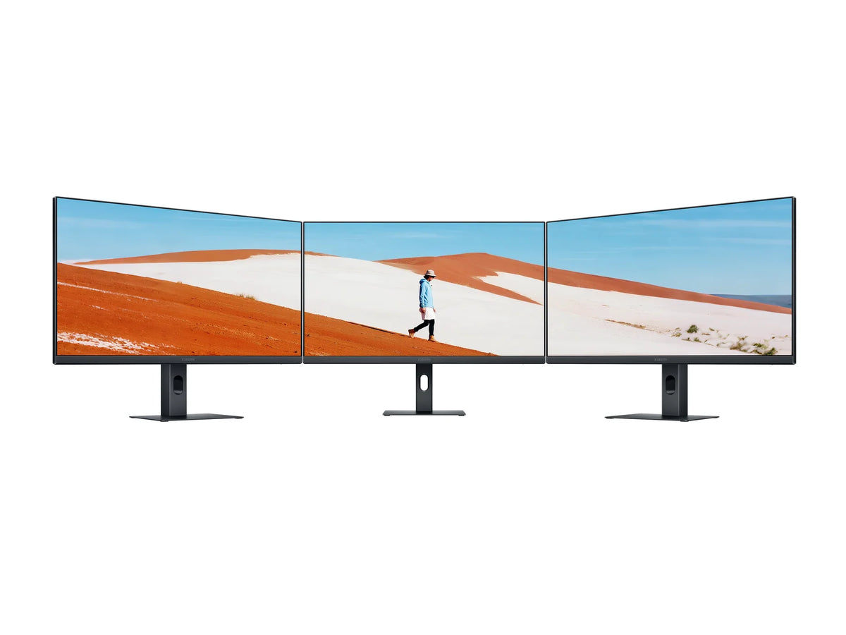 Drie Xiaomi Monitor A24i 2026-schermen naast elkaar met een doorlopend woestijnbeeld