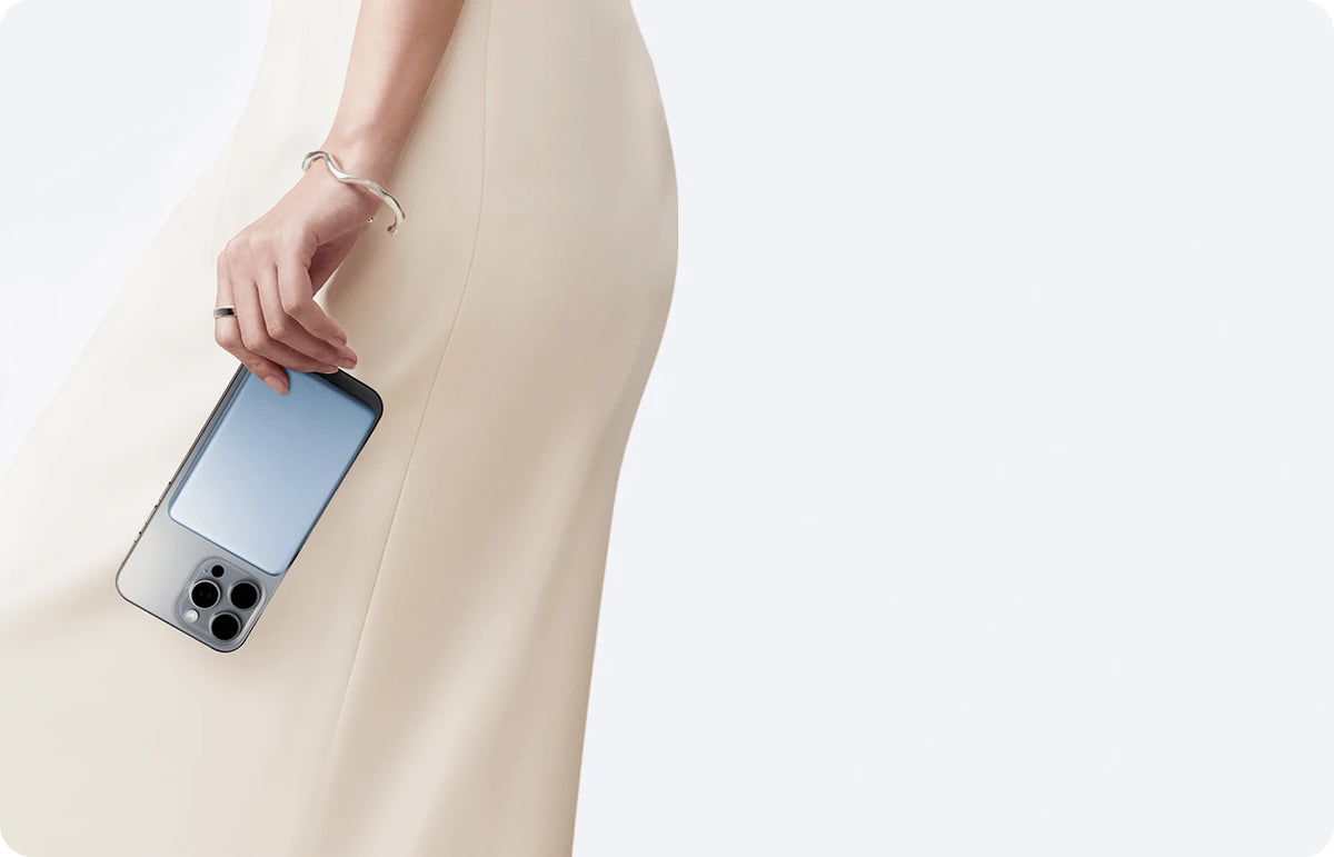 Telefoon met de Xiaomi Super Slim Magnetic Power Bank 5000 in de hand