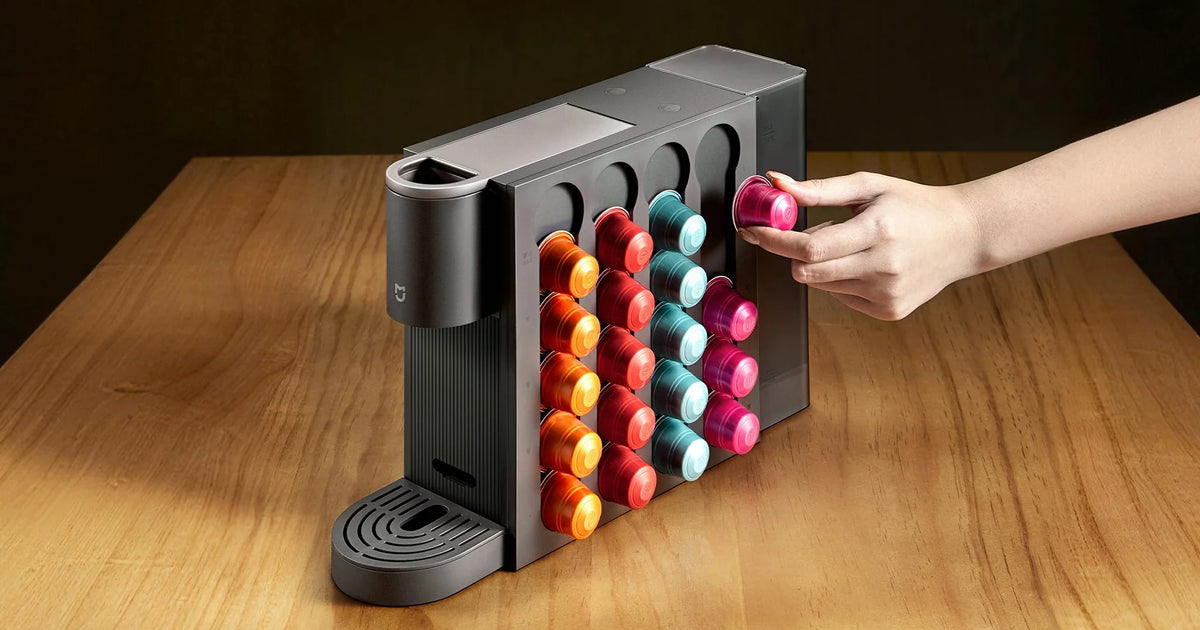 Hand pakt een capsule uit de houder aan de zijkant van de Xiaomi Mijia Capsule Coffee Machine