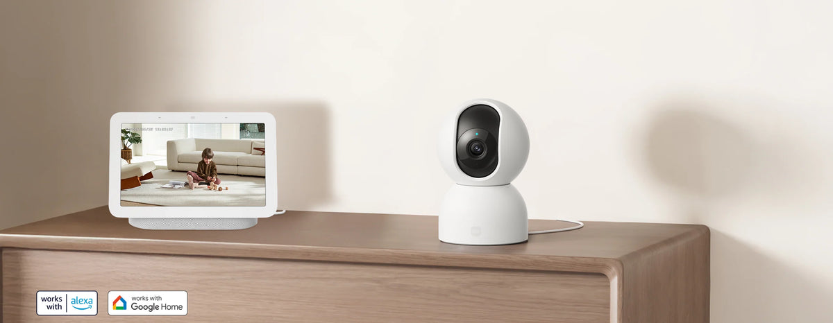 Xiaomi Smart Camera C401 op een dressoir naast een smart display met het livebeeld