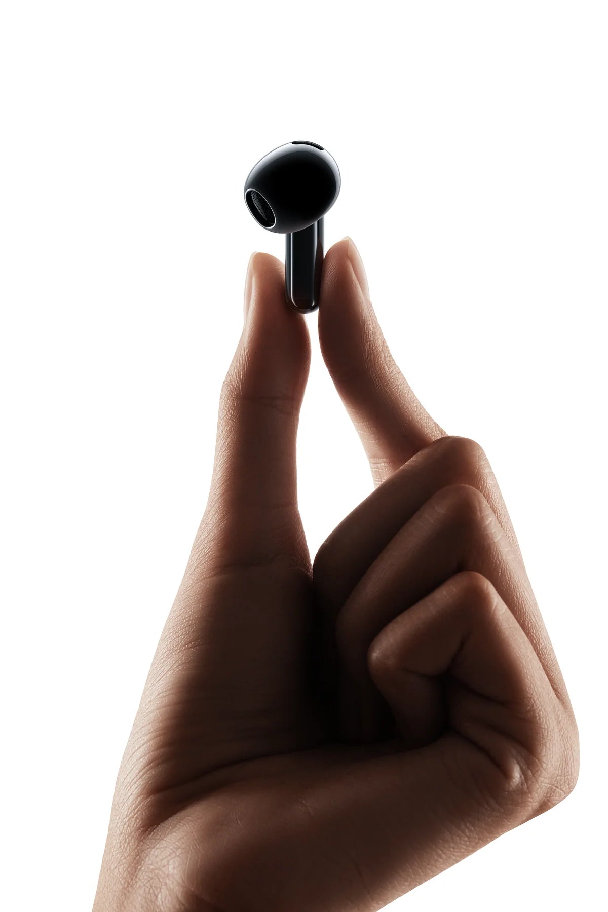 Zwart dopje van de Xiaomi Buds 6 van 4,4 gram tussen duim en wijsvinger
