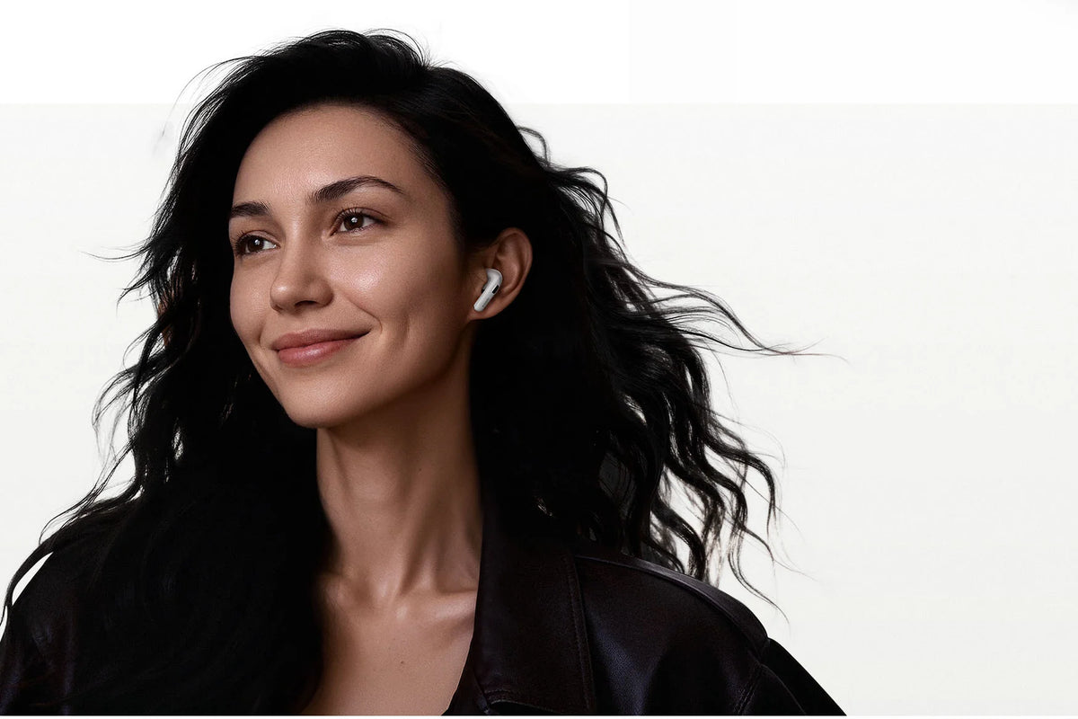 Vrouw met de Xiaomi Buds 6 in, glimlachend