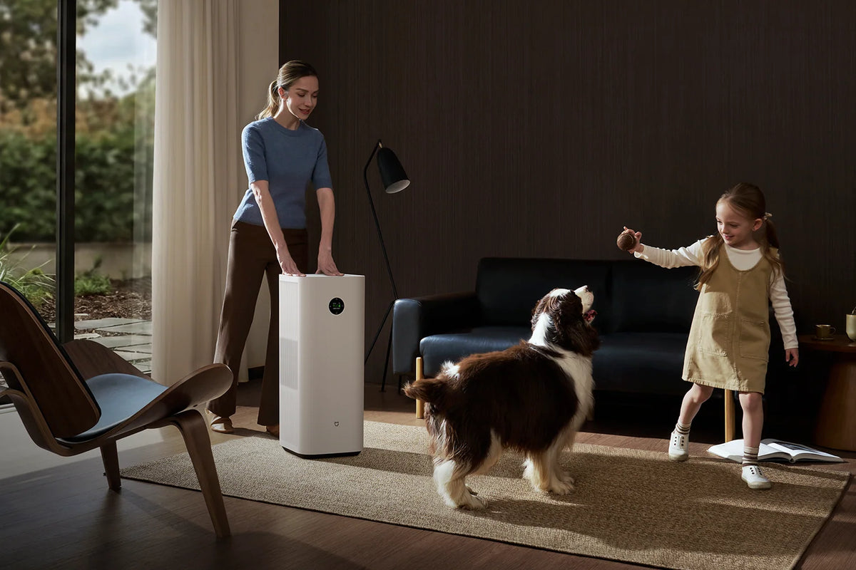 Vrouw verrijdt de Xiaomi Mijia Smart Air Purifier 6 Plus terwijl haar dochter met de hond speelt