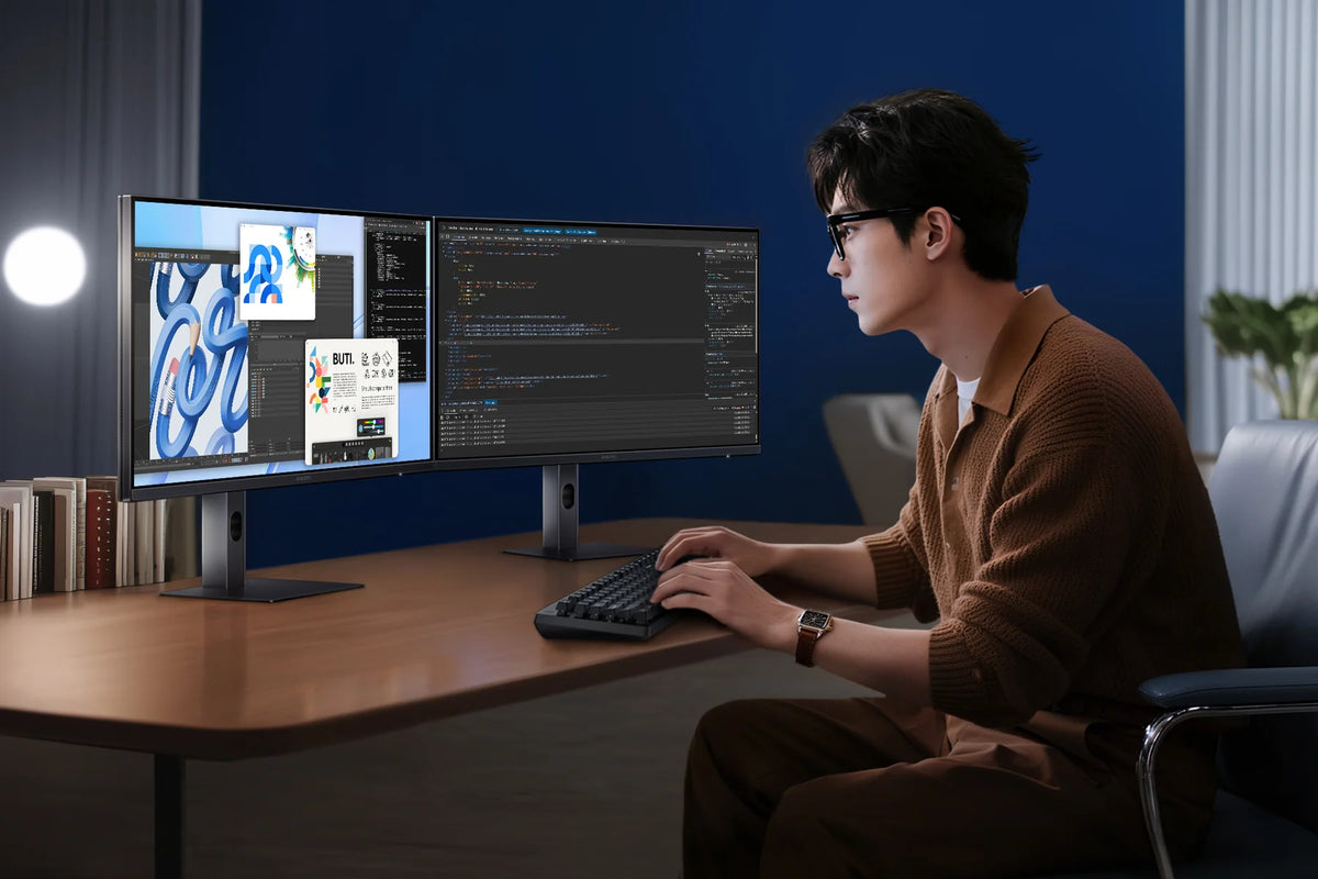 Man aan het werk met twee vensters op de Xiaomi 2K Monitor A27Qi 2026