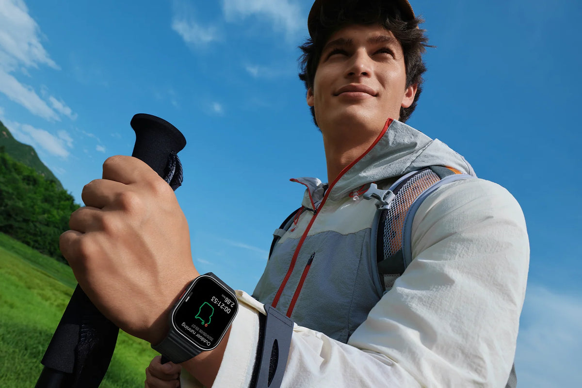 Wandelaar met de Xiaomi Redmi Watch 6 Lite en wandelstokken in de bergen