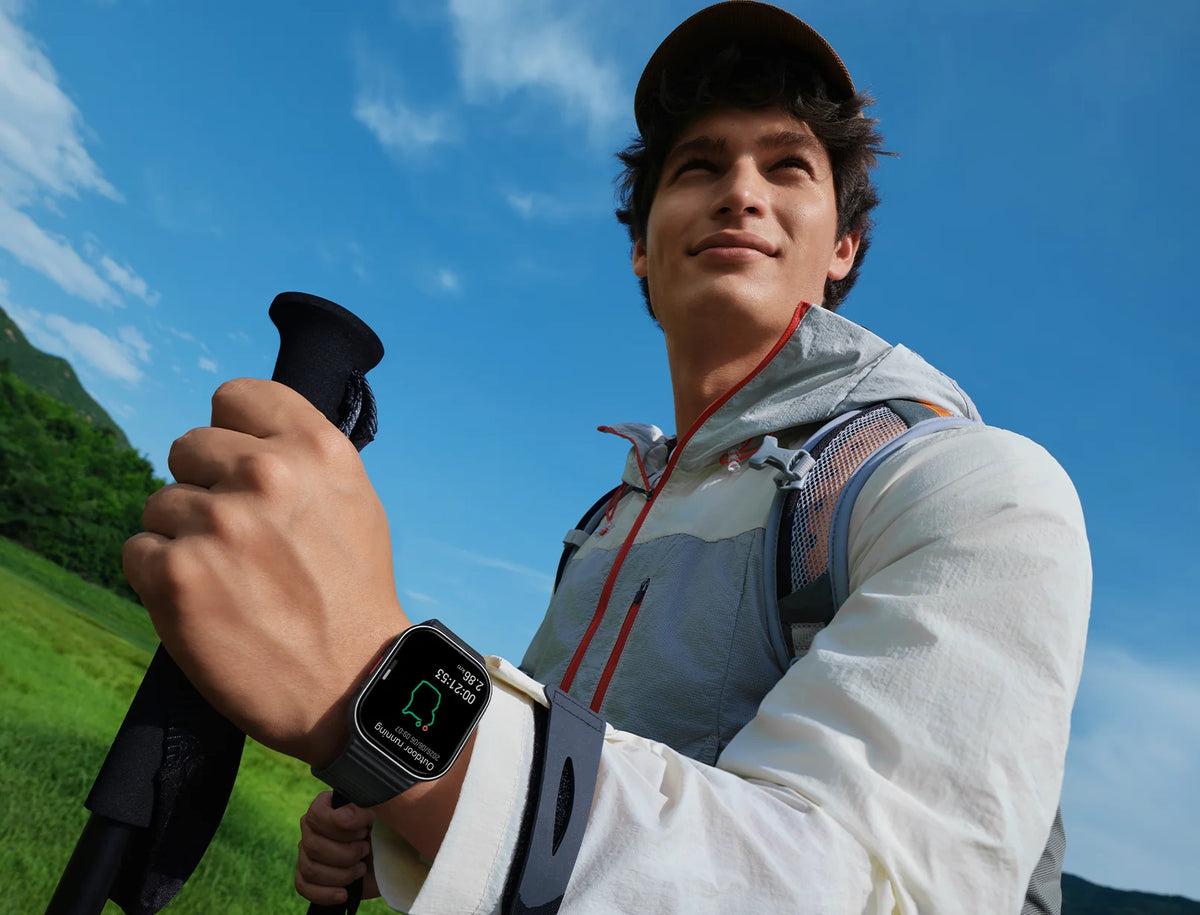 Wandelaar met de Xiaomi Redmi Watch 6 Lite en wandelstokken in de bergen