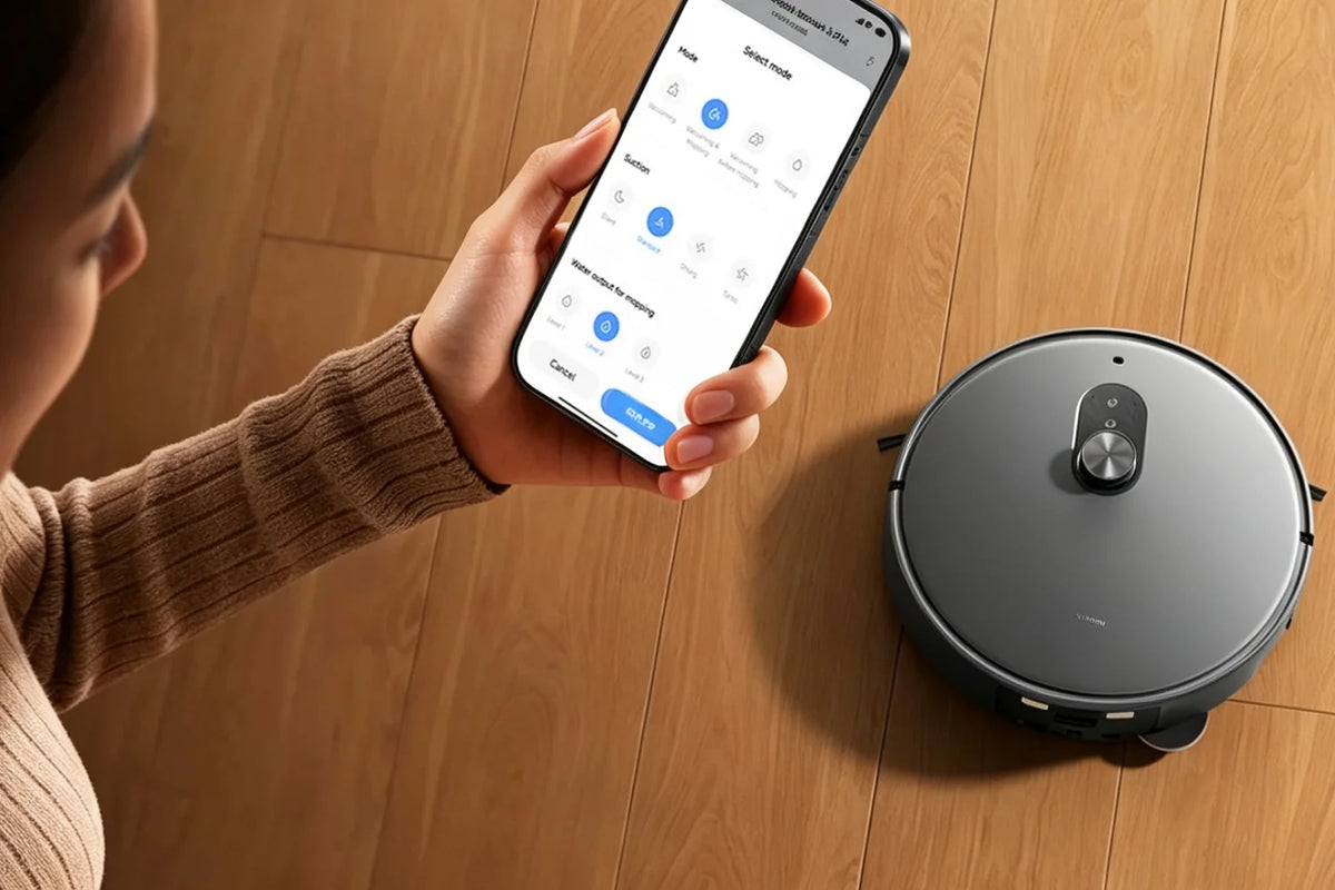 Iemand bedient de Xiaomi Robot Vacuum 6 Max met de app op een houten vloer